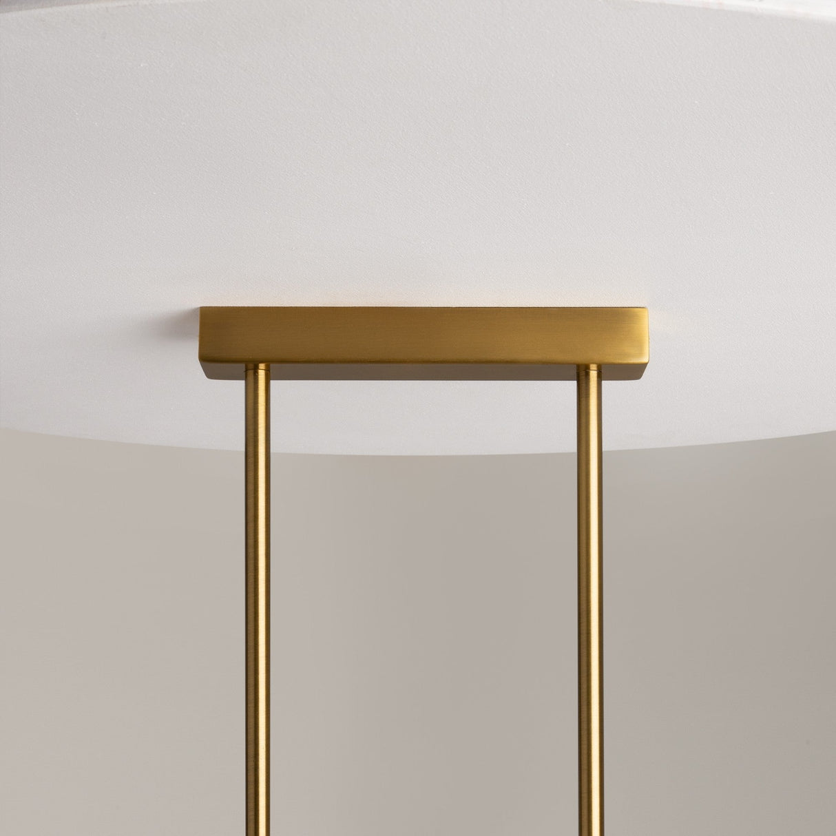 Close-up of the Miracle 5 Light Linear Suspension Light showcasing its minimalist design with brass-finished rods extending from a rectangular base and smooth cast glass shades, all set against a light gray background.