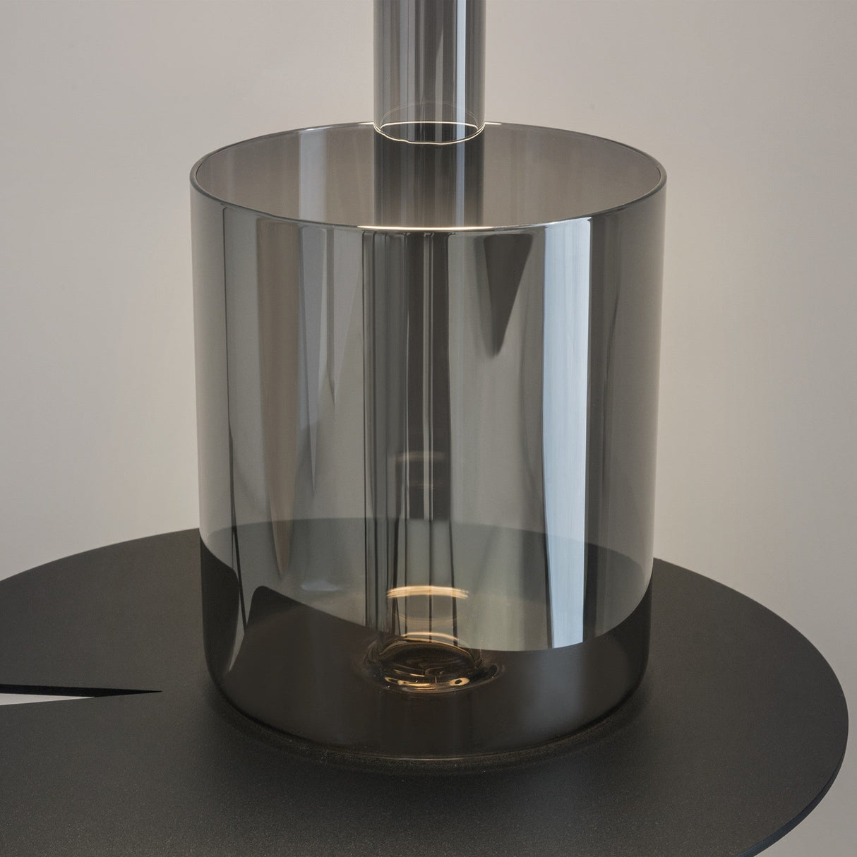 The AI Collaboration Rechargeable LED Table Lamp features a smoked gray glass vase on a sleek black circular base. Its modern design includes a cylindrical, translucent body with visible soft light, set against a neutral background.