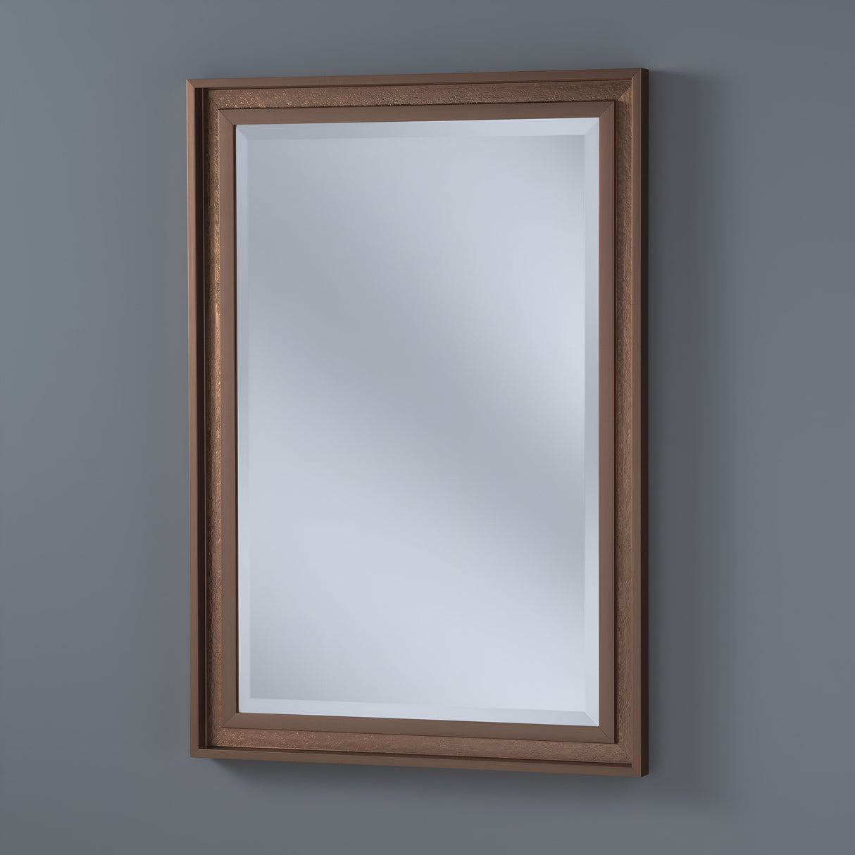 The Artivis Rectangle Wall Mirror - Bronze, mounted on a gray wall, features a wooden frame with a beveled design. Its reflection captures a neutral, well-lit environment, enhancing the rustic charm of the setting.