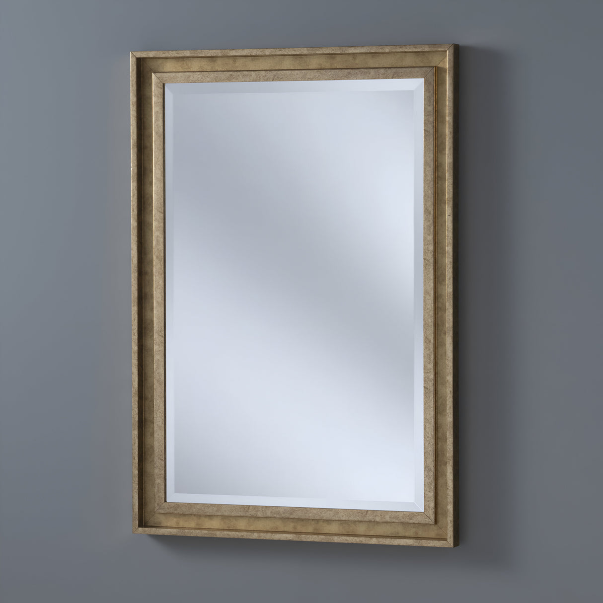 The Artivis Rectangle Wall Mirror - Gold hangs on a gray wall, and its beveled edges enhance its elegance, making it ideal for contemporary interiors.