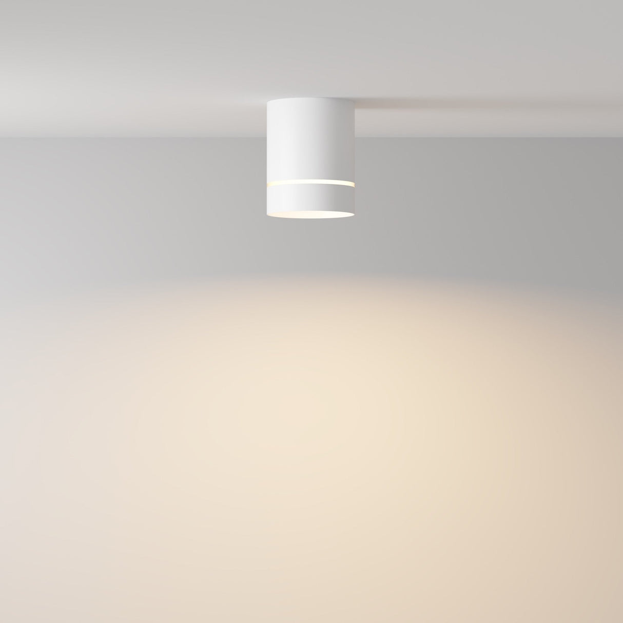 The Orlo LED Round Surface Downlight 9W 3000K - White brightens a minimalist room, casting a soft glow on light-colored walls and enhancing the simple, calm ambiance with energy-efficient lighting.