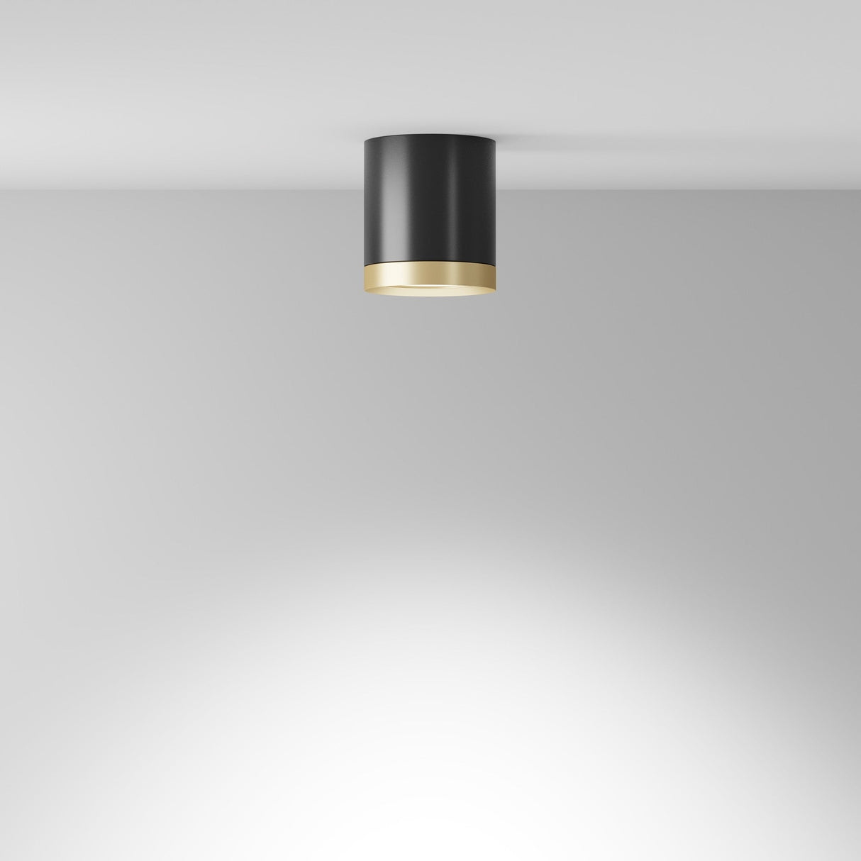 The Hoop Medium Round Surface Downlight in black and gold is a ceiling-mounted LED fixture with a sleek matte finish and elegant gold trim, casting a soft glow on white ceilings and walls to embody modern sophistication.