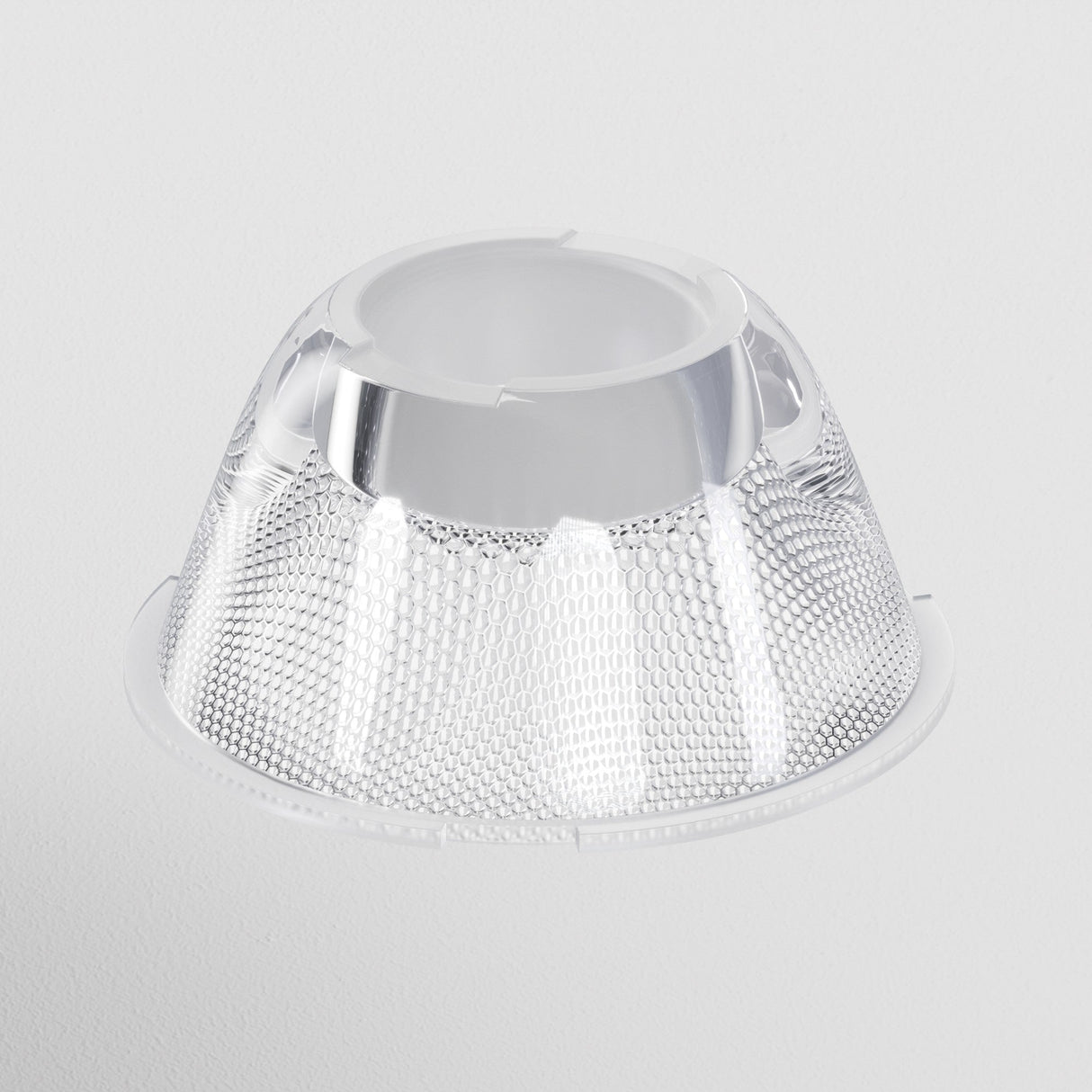 The Focus LED Track Light Lens ⌀43mm 50° is crafted from translucent, textured plastic with a honeycomb pattern. Its wide base and narrow top deliver ambient lighting, while its reflective surface and modern design stand out against a white background.