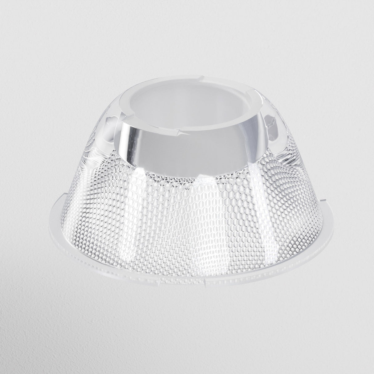 A close-up of a transparent, dome-shaped light fixture with a honeycomb pattern. The Focus LED Track Light Lens ⌀55mm 15° perfectly highlights the details against a plain white background.