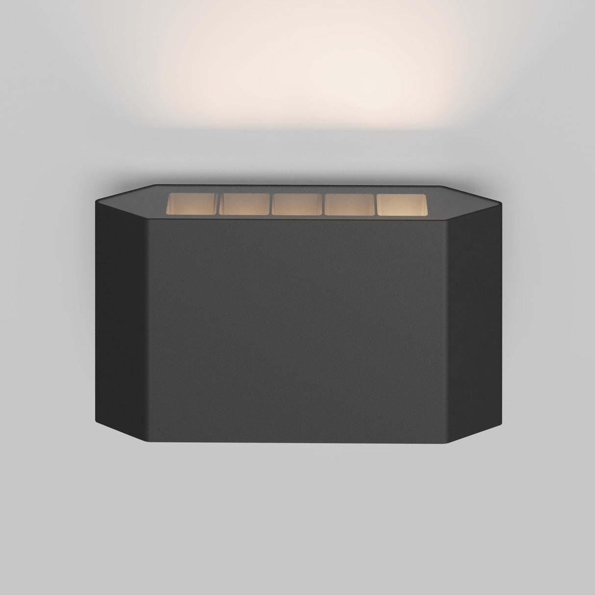 The Pull Outdoor LED Wall Light 5W 3000K in graphite features a modern rectangular design with a front grid pattern, emitting a soft white glow upwards, and offers an IP54 protection rating.