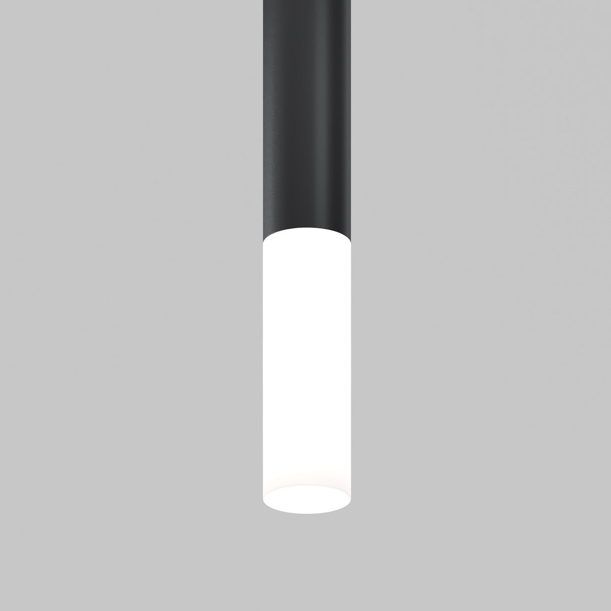 The Focus LED Light Diffuser Large 12W is a minimalist cylindrical ceiling fixture with a black metal housing and an LED diffuser that emits bright white light, reducing glare. Its translucent lower half offers ambient lighting against a plain gray background.