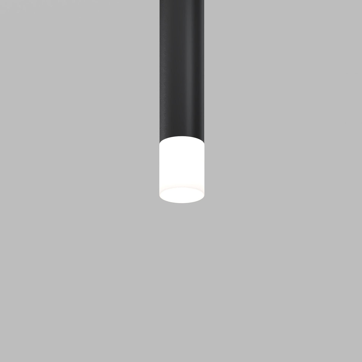 The black cylindrical pendant, featuring the Focus LED Light Diffuser Medium 5W and a glowing white bulb, is elegantly suspended against a plain gray background.