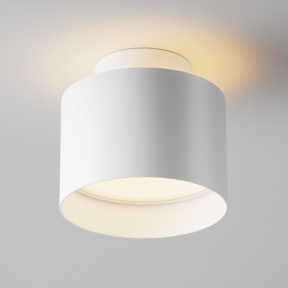 The Planet LED Small Round Surface Downlight 3000K - White is a modern, cylindrical ceiling fixture with a minimalist design and energy-efficient lighting. It emits a soft, warm glow and casts gentle illumination while being flush-mounted for a sleek and sophisticated look.