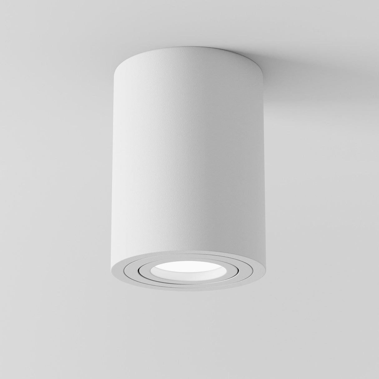 The Atom Round Surface Mounted Downlight - White is a modern cylinder light fixture with a matte finish, featuring a minimalist design that enhances spaces with its subtle elegance against a plain white background.