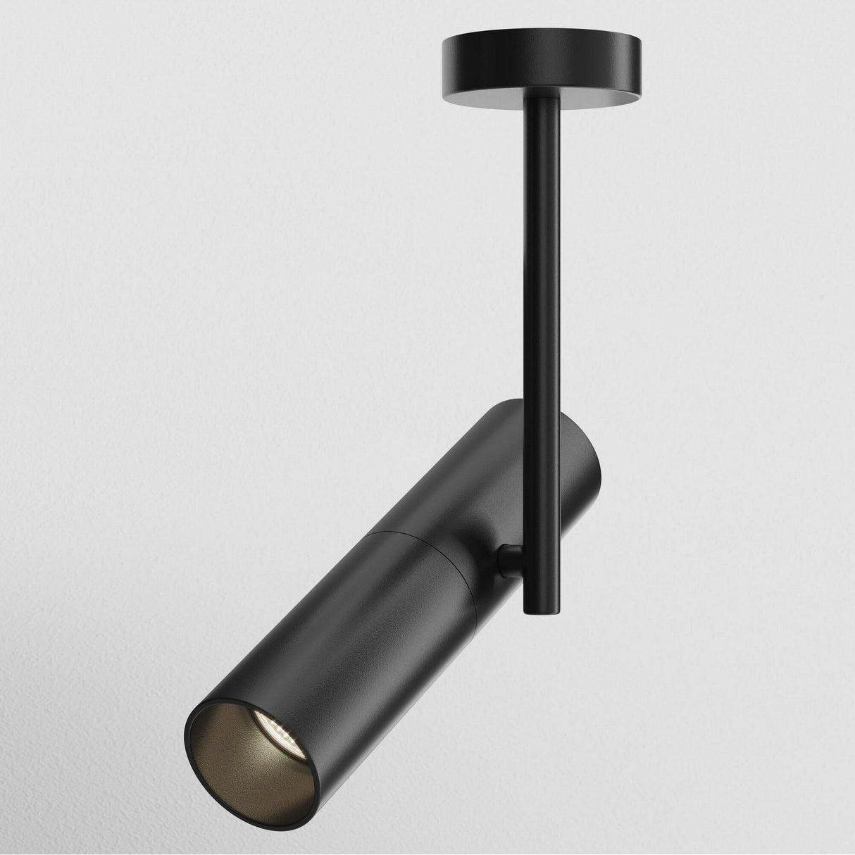 The Elti Single Spotlight - Black is a modern industrial fixture with a sleek cylindrical design on a rod, offering adjustable lighting for optimal downward illumination against a plain white background.