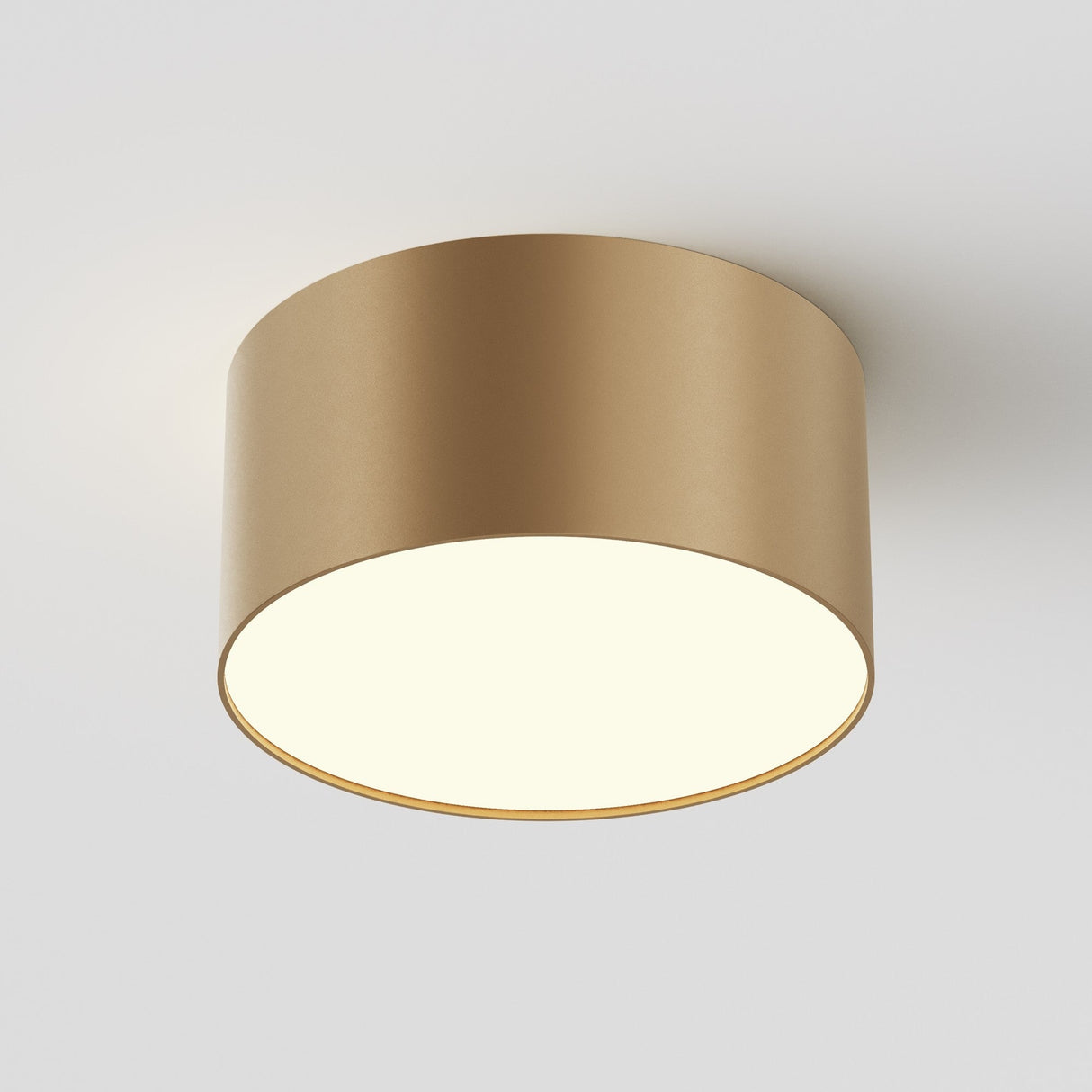 The Zon LED Downlight 3000K 12W in matte gold is a ceiling-mounted, circular light with a minimalist design. Its flat, smooth surface and soft lighting create a luxurious ambiance against a plain white ceiling.