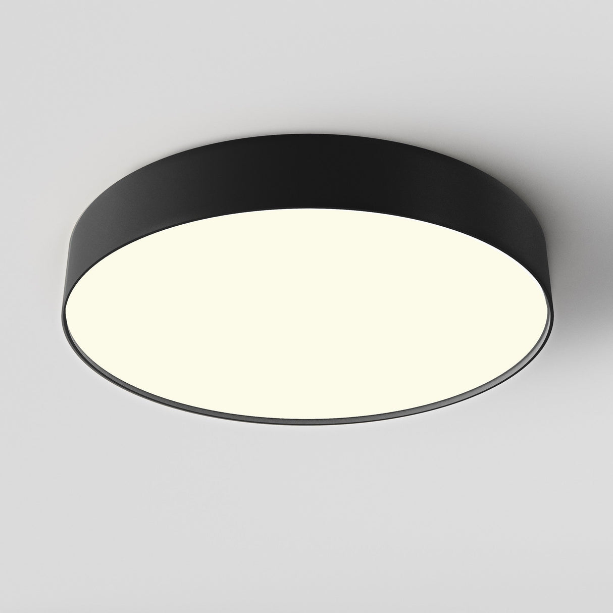 The Zon LED Medium Flush Ceiling Light 3000K 45W showcases a modern matte black frame with a bright white illuminated center against a plain white ceiling.