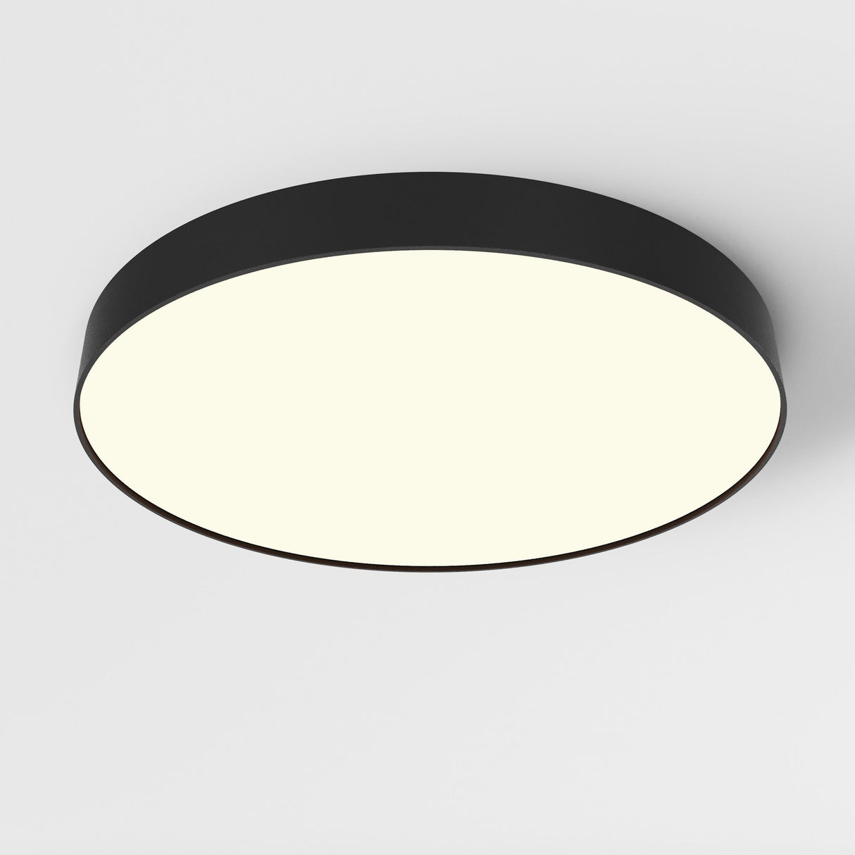 The Zon LED Large Flush Ceiling Light 3000K 90W - Black, with its modern design and soft ambient glow, perfectly complements contemporary interiors when mounted on a white ceiling.