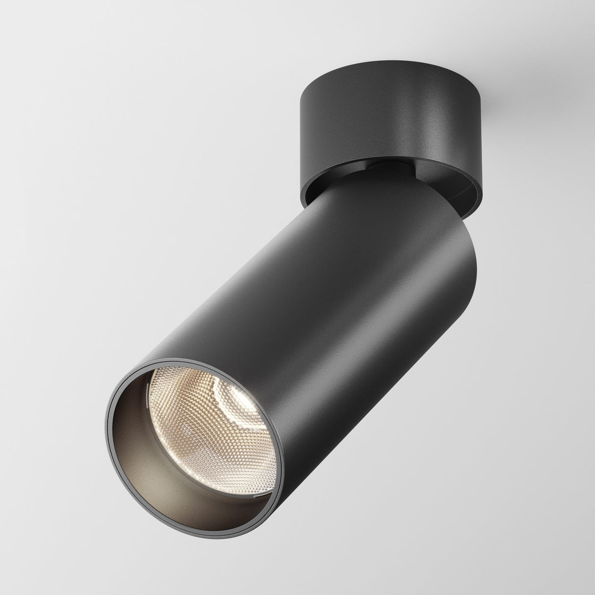 The Focus LED Single Surface-Mounted Spotlight 12W 3000K in black features a sleek cylindrical design, offering energy-efficient lighting. It emits light at a downward angle, highlighting its modern and minimalist aesthetic against a plain white background.