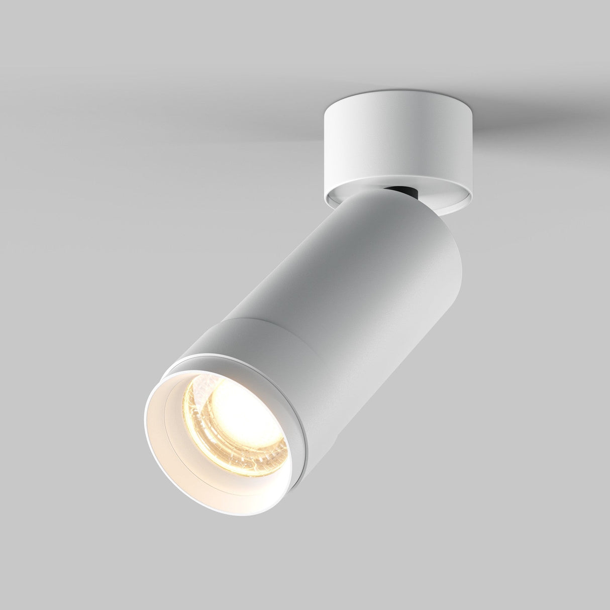 The Focus Zoom LED Single Surface-Mounted Spotlight 12W 3000K - White is a modern, cylindrical design spotlight mounted on a round base. It has an adjustable beam angle and illuminates with a warm glow against a light gray background.