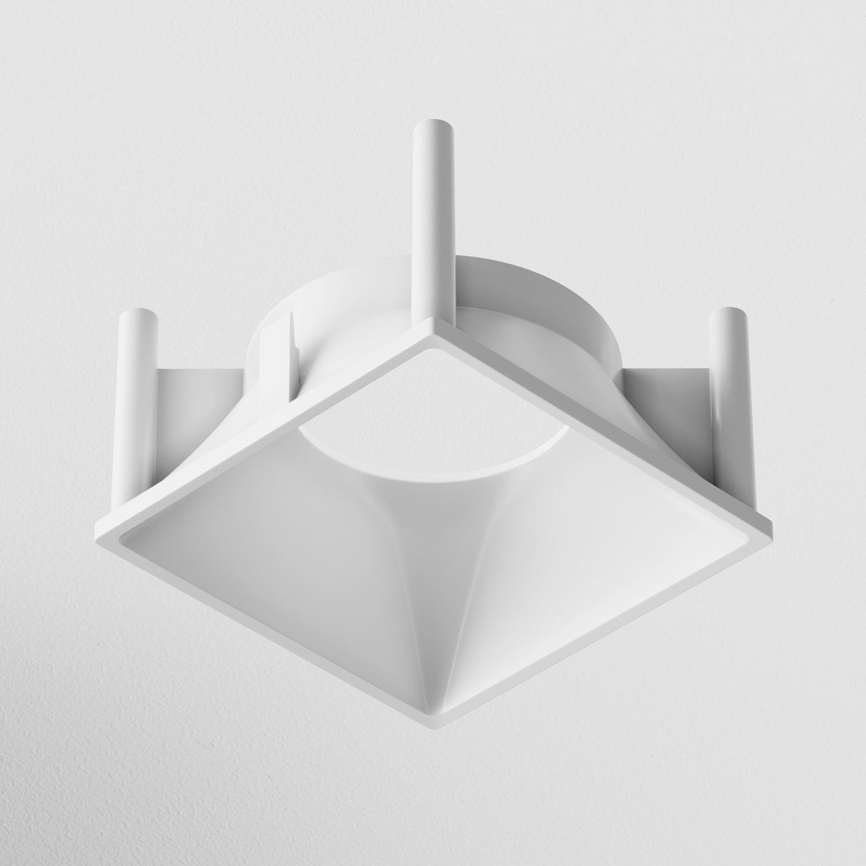 The Alfa LED Square Decorative Reflector Frame - White is a minimalist ceiling light with a square base, circular opening, and cylindrical supports, offering clean lines and a modern look.