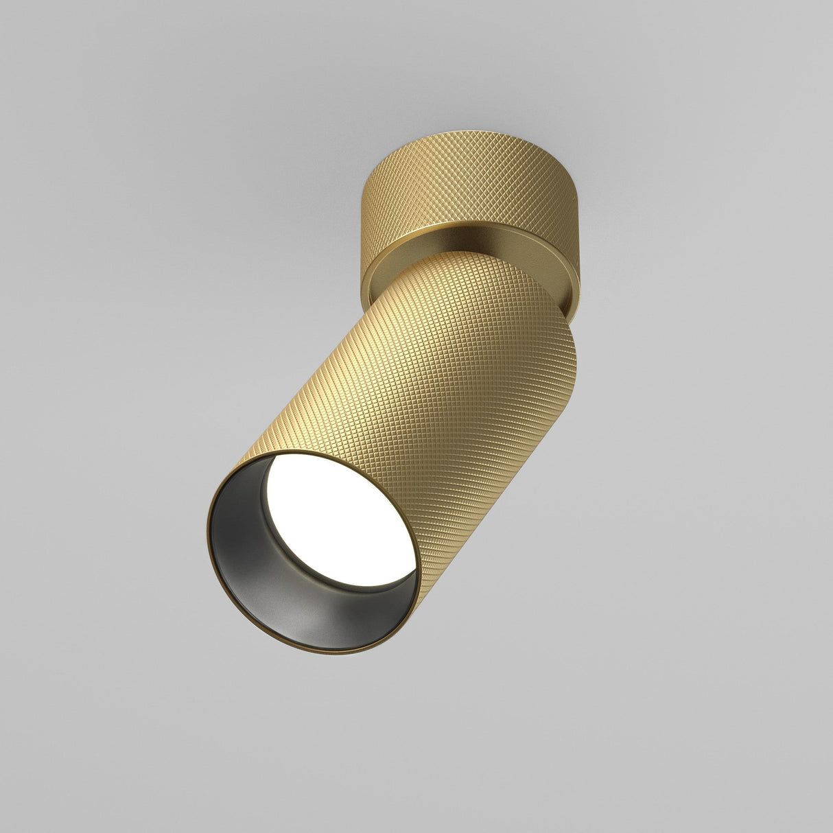 Artisan Single Spotlight - Matte Gold: This cylindrical ceiling fixture, with its textured surface, emits a soft, focused beam of light against a plain gray background, encapsulating contemporary luxury.
.