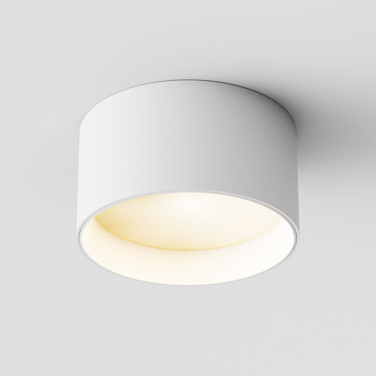 The Vega LED Round Surface Downlight 12W 3000K - White features a sleek cylindrical design for modern, minimalistic appeal and high-quality illumination with excellent color rendering (CRI 90) against a white ceiling.