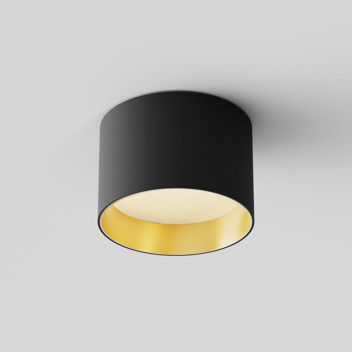 The Vega LED Round Surface Downlight 8W 3000K in black and matte gold features a modern cylindrical design with energy-efficient technology, creating a warm, reflective interior that casts a soft ambient glow against a white ceiling.