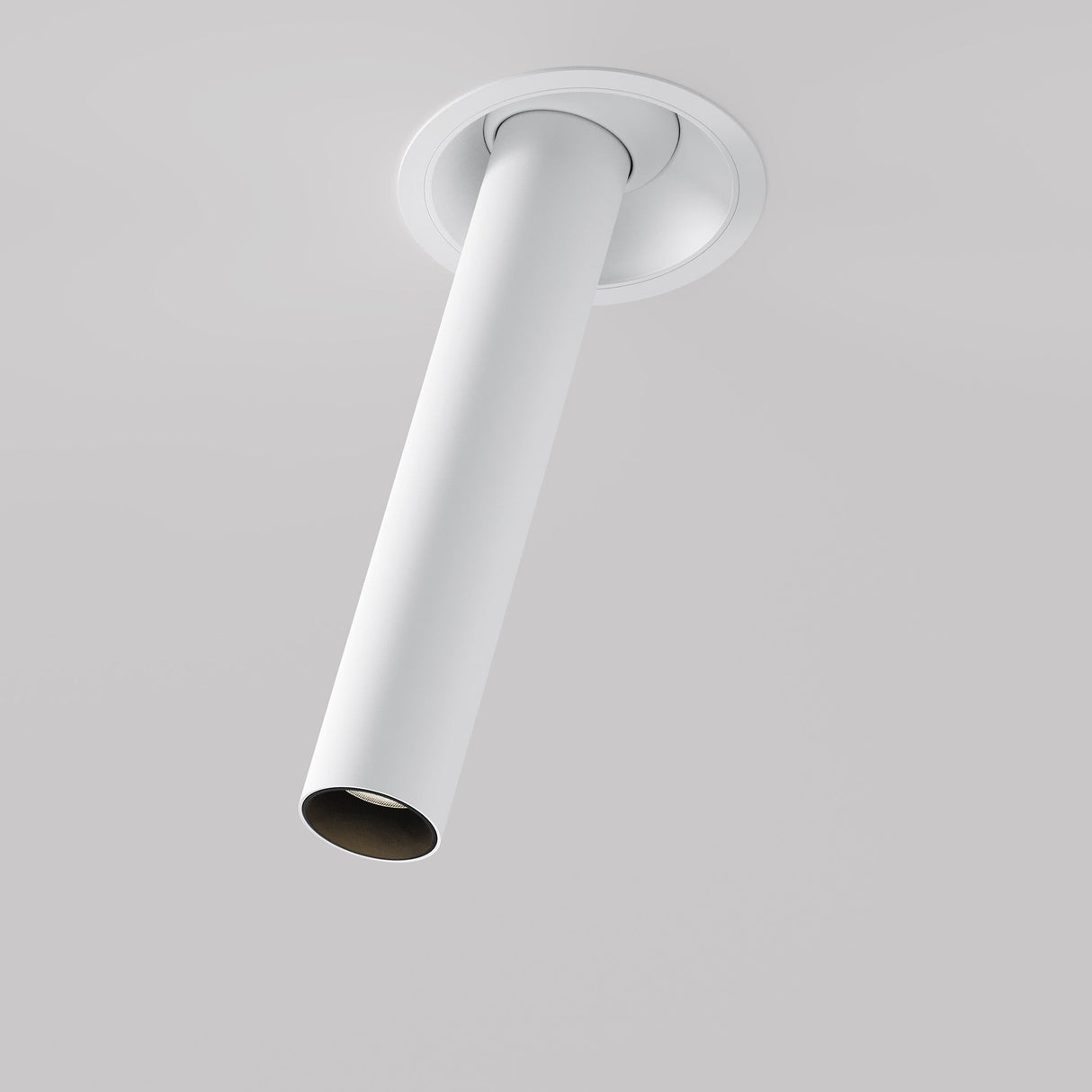 The Focus T LED Adjustable Long Retractable In-Out Recessed Downlight 7W 3000K in white features a minimalist cylindrical design, angled downward. It complements a plain white ceiling for a sleek and modern appearance.