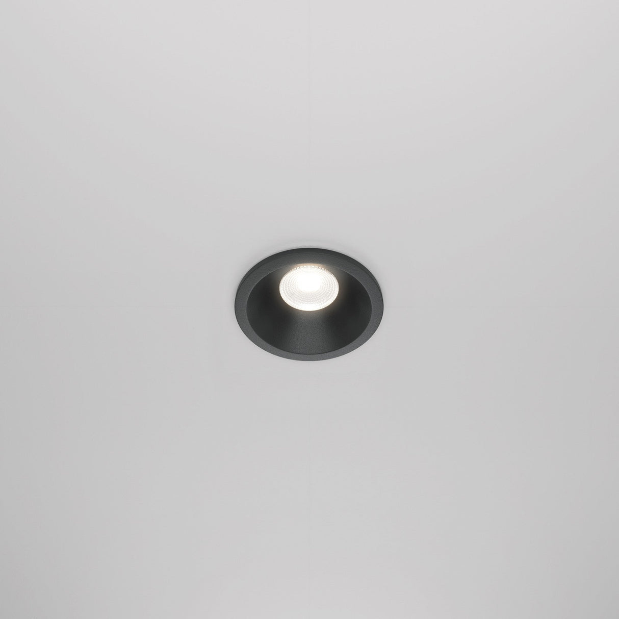 The Zoom LED Dimmable Round Recessed Downlight 6W 4000K in black is a ceiling-mounted light with a circular frame that emits a bright, focused beam. Its minimalist design and IP65 rating make it perfect for versatile environments.