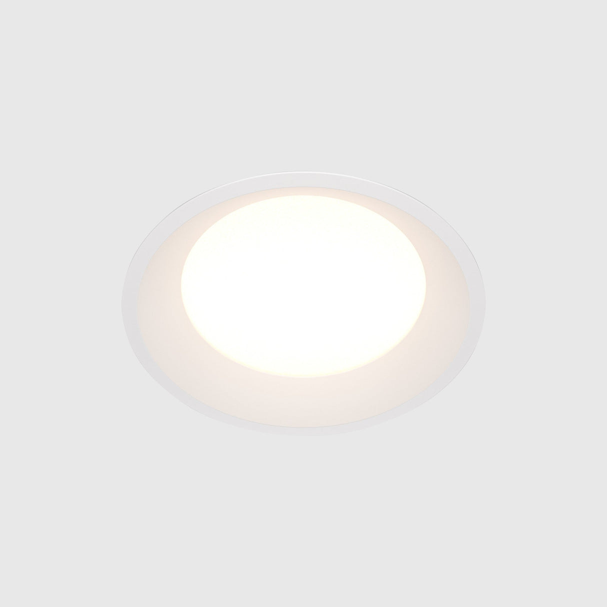 The Okno LED Round Recessed Downlight 18W 4000K, set in a white ceiling, emits a soft glow. This energy-efficient fixture embodies minimalism with its smooth, modern design.