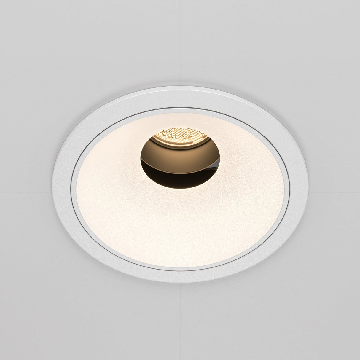 The Wise LED Round Recessed Downlight 10W 3000K features a minimalist white trim with a warm LED bulb, partially visible inside a textured interior, against a smooth light-colored ceiling surface.