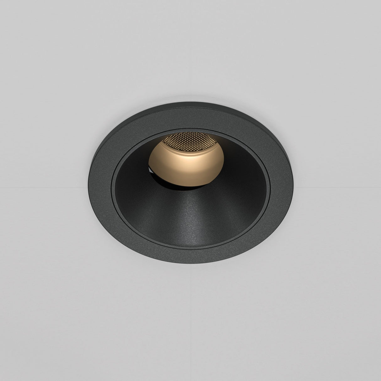 The Wise LED Round Recessed Downlight 7W 3000K in black features a sleek, black circular frame with a gold inner surface, housing an LED spotlight that complements the white ceiling.