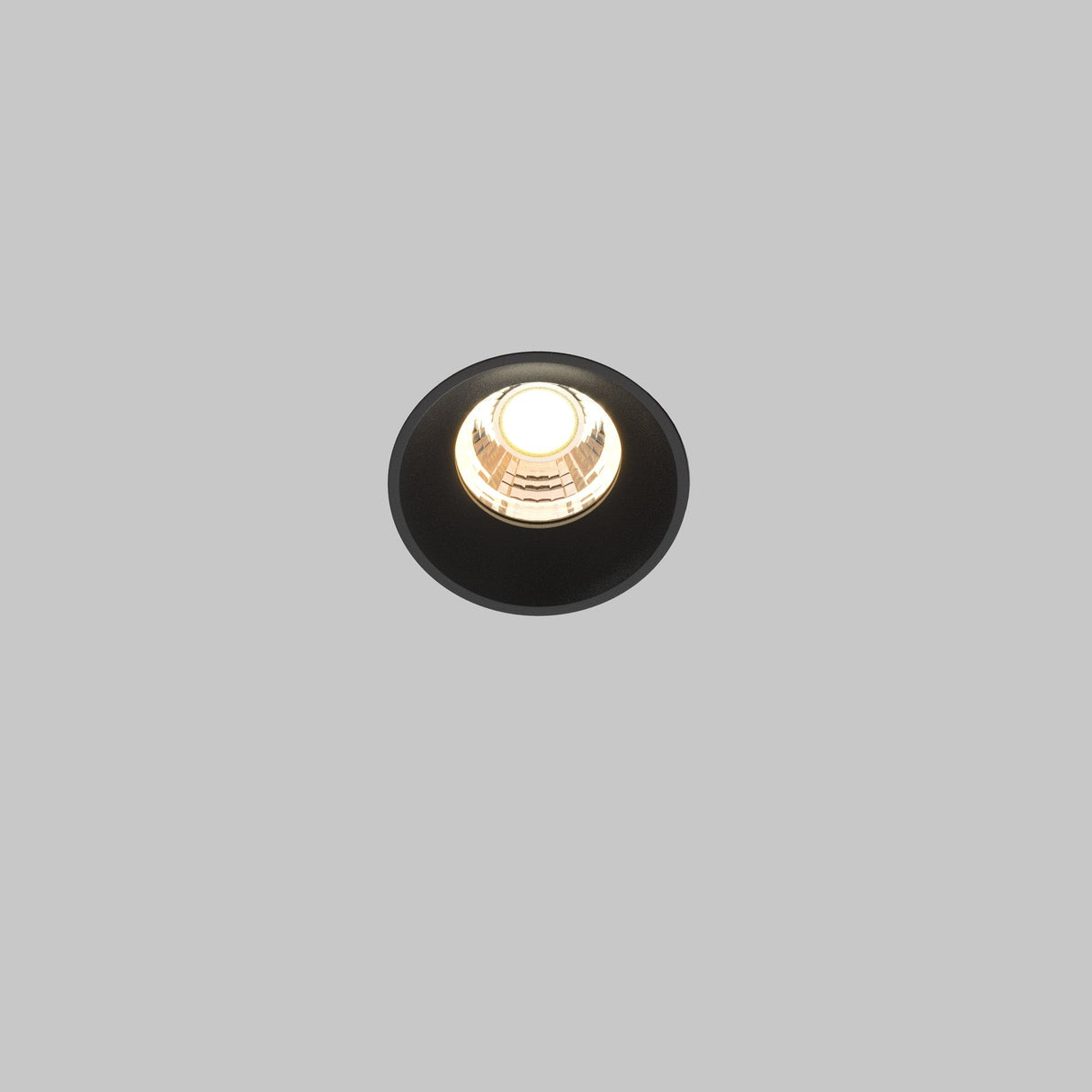 The Round LED Recessed Trimless Downlight 7W 3000K - Black, set against a gray background, is turned on and emits a circular glow, exemplifying its energy-efficient lighting.