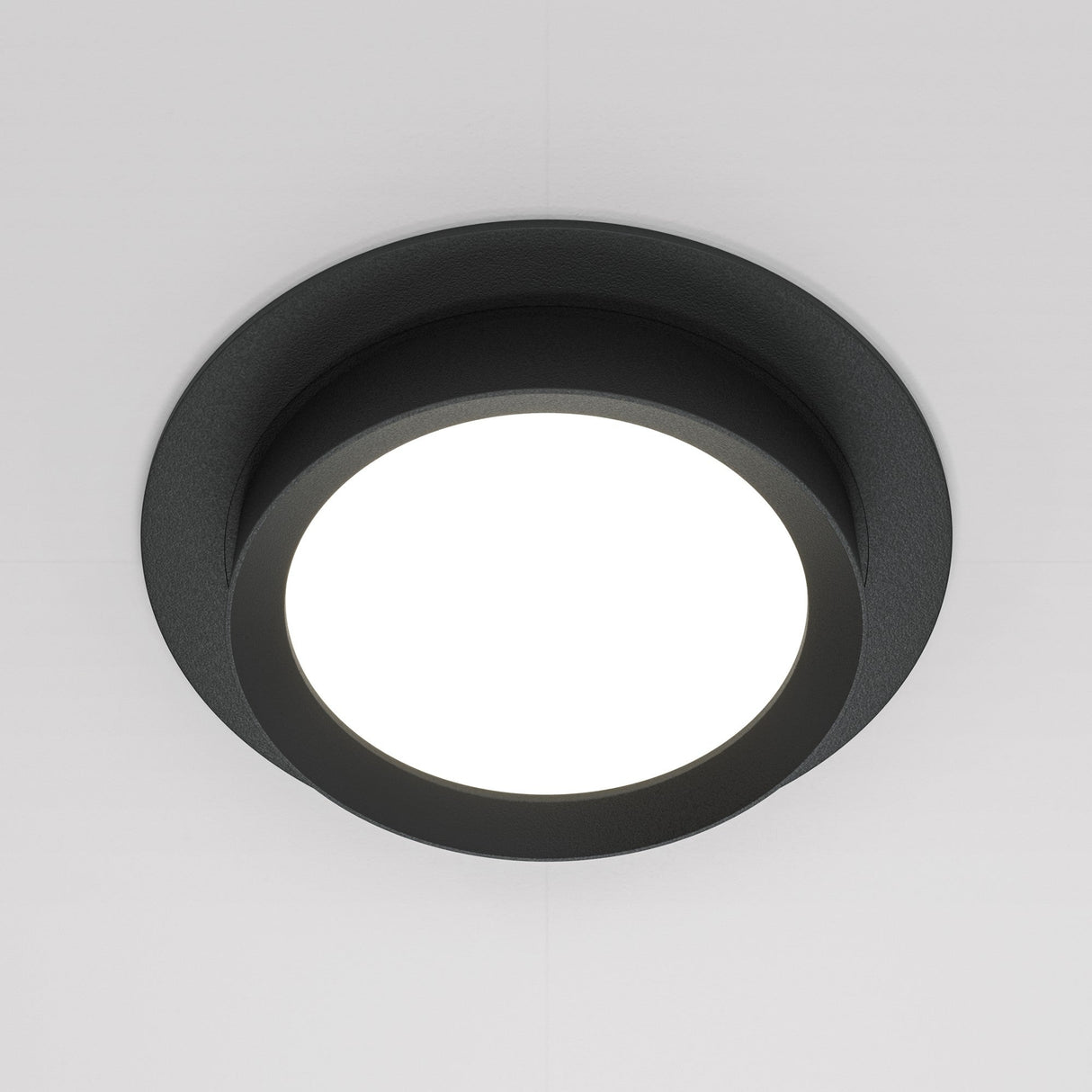 The Hoop Single Fixed Round Recessed Downlight in black offers a modern, minimalist design with an energy-efficient LED center that brightens light-colored ceilings with its vibrant glow.