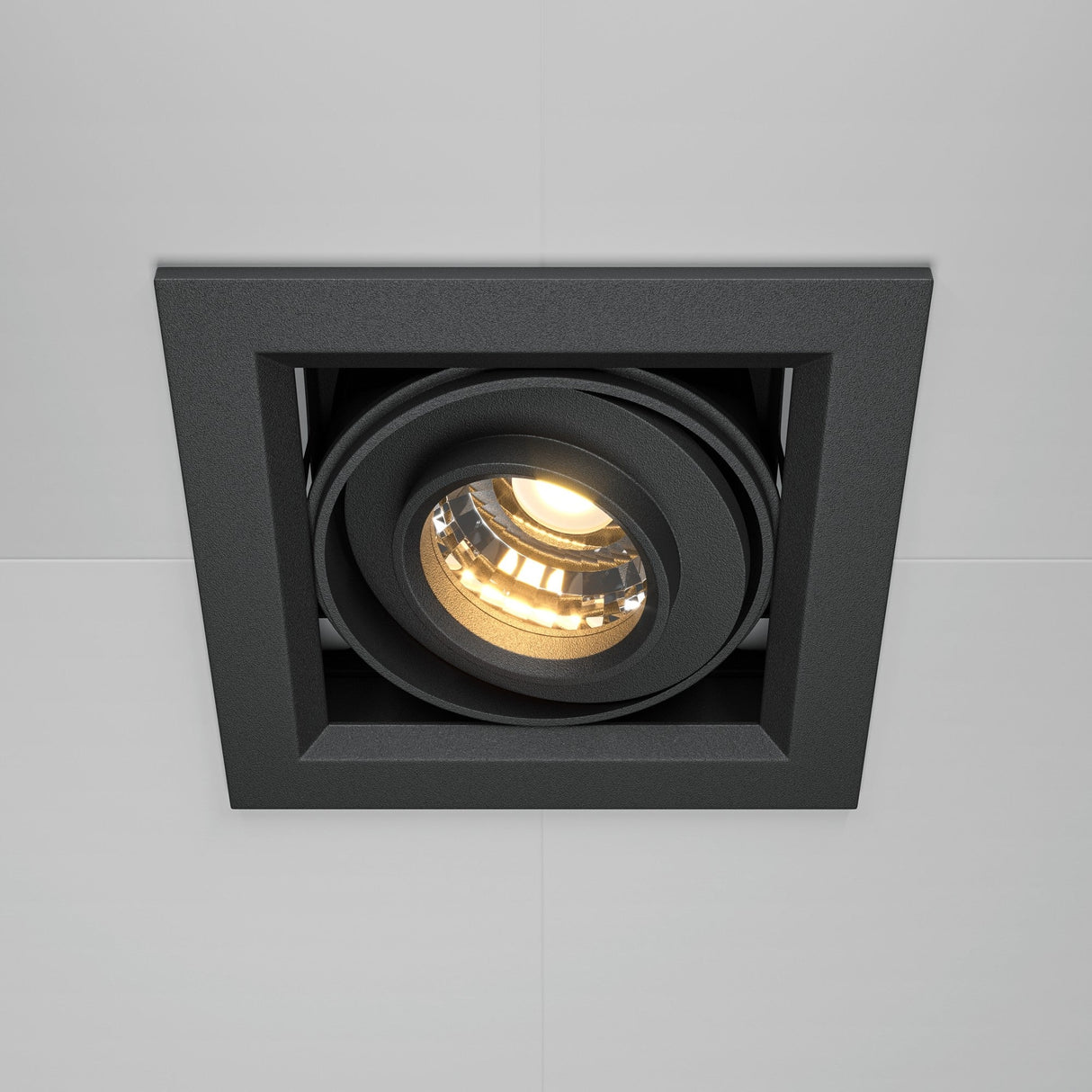 The Metal Modern LED Square Recessed Downlight 10W 3000K - Black features a stylish black frame and circular light, offering a warm glow ideal for energy-efficient lighting. Embedded seamlessly into a light ceiling, it elevates any contemporary interiors aesthetic.