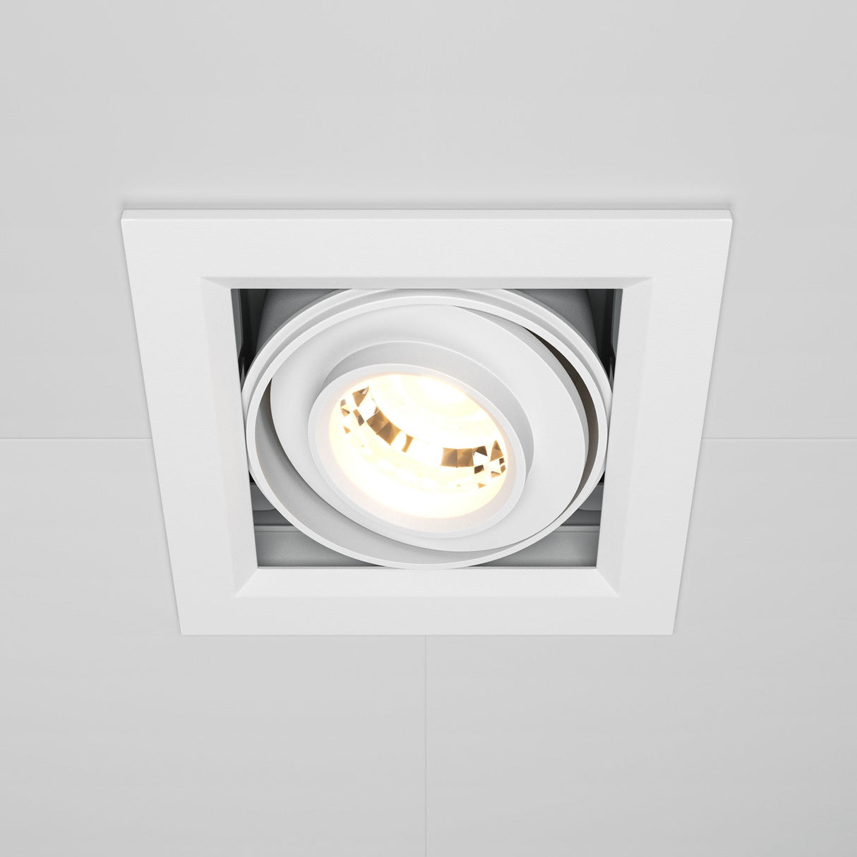 The Metal Modern LED Square Recessed Downlight 10W 3000K in white features a sleek, adjustable tilting mechanism and emits a bright glow from its circular light source, blending seamlessly with white ceilings for modern lighting.