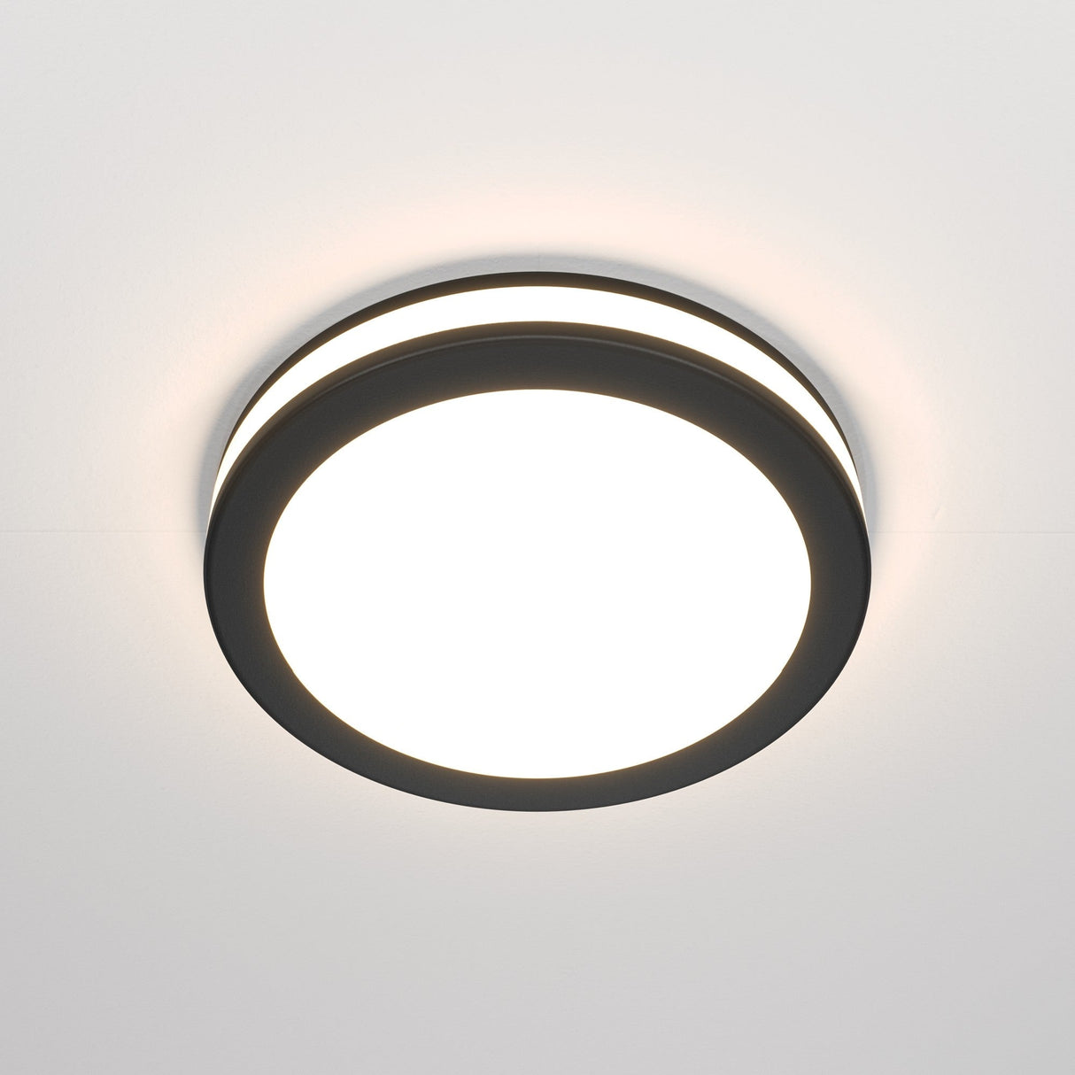 The Phanton LED Recessed Downlight 12W 3000K - Black features a modern, round black rim with a bright white center. Its minimalist design fits seamlessly on white ceilings, offering balanced illumination and a wide 120° beam angle for an elegant touch.
