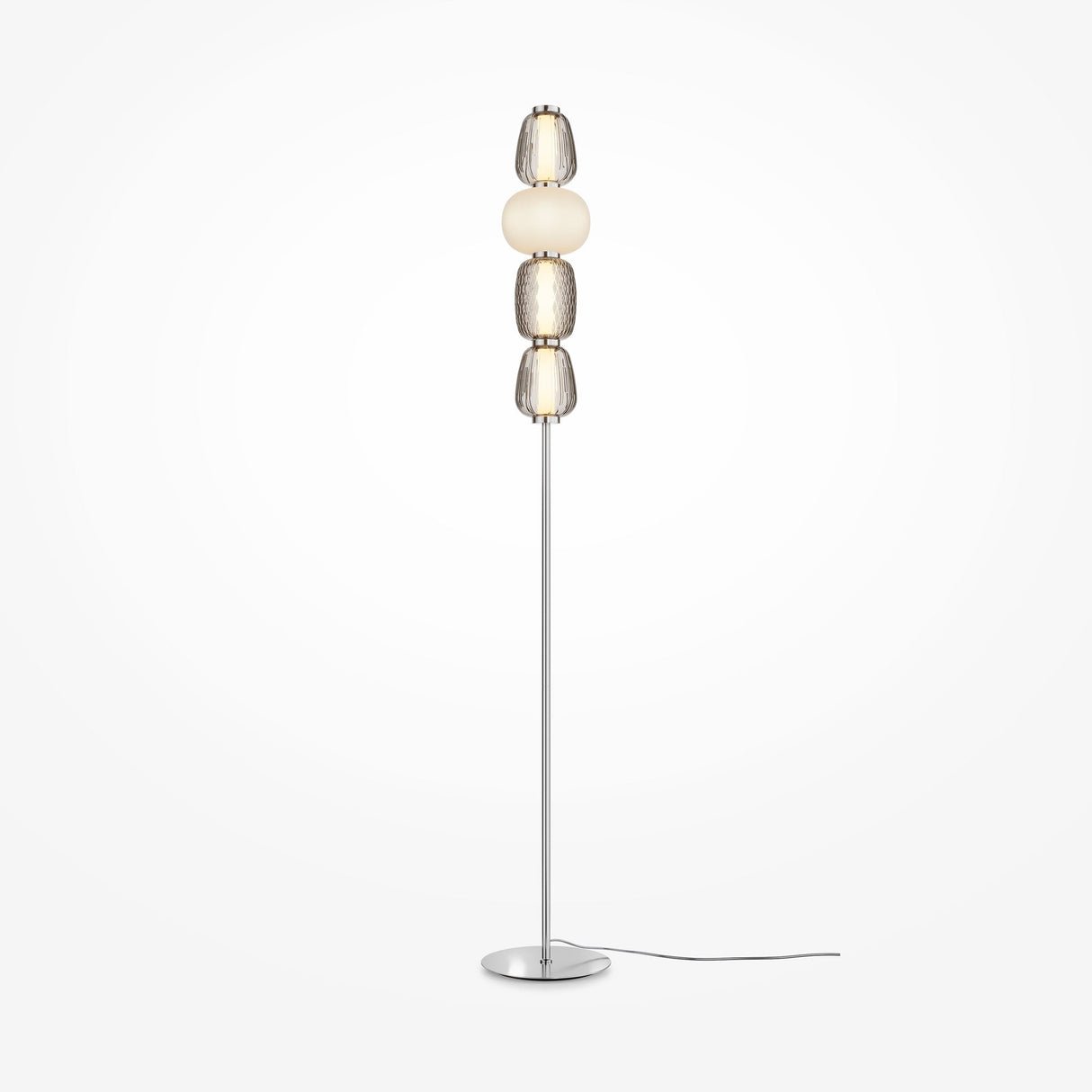 The Pattern LED Floor Lamp - Chrome is a tall, modern lamp with a slim metal stand and circular base featuring stacked spherical shades in shiny metallic and frosted white finishes, enhanced by chrome fittings, with an energy-efficient power cord.