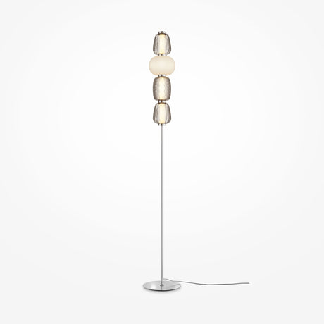 The Pattern LED Floor Lamp - Chrome is a tall, modern lamp with a slim metal stand and circular base featuring stacked spherical shades in shiny metallic and frosted white finishes, enhanced by chrome fittings, with an energy-efficient power cord.
