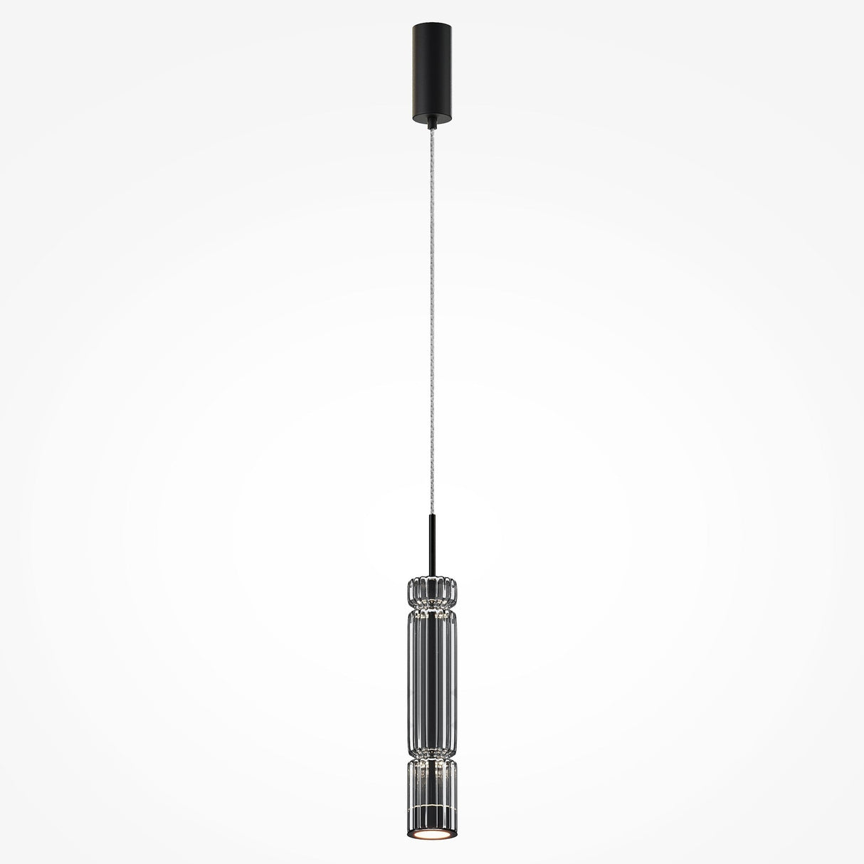 The Ordo LED Short Pendant Light, featuring a sleek cylindrical black housing and smoky glass, hangs by a thin wire from the ceiling, providing focused downward illumination.