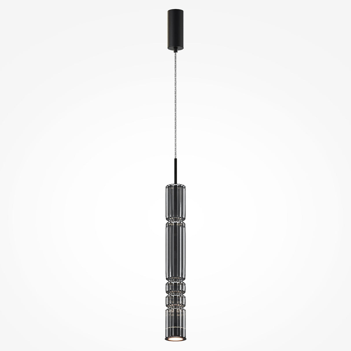 The Ordo LED Long Pendant Light features a sleek black finish with cylindrical smoky glass, vertical ridges, and an integrated LED. It hangs from a thin black cord attached to a matching ceiling mount, creating depth against a plain white background.