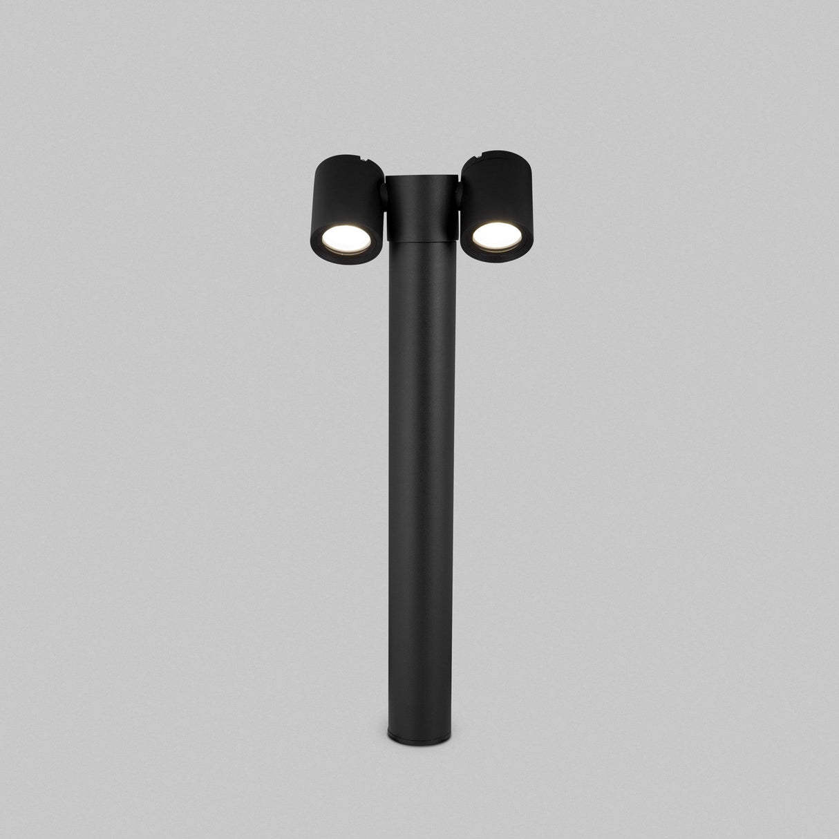 The Wall Street 2 Light Bollard 55cm in black showcases a sleek, modern design with adjustable dome lamps arranged in a T-shape. Its minimalist style stands out against a plain gray background, embodying a contemporary aesthetic.