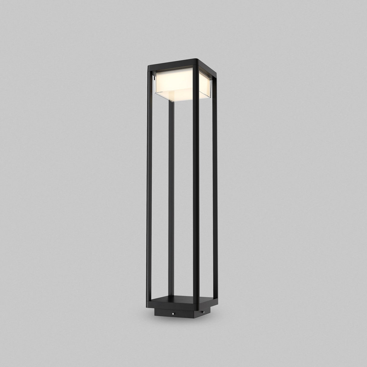 The Baker Street Pedestal Light - Black is a tall, modern floor lamp with a minimalist black rectangular frame and bright LED lighting, perfect for standing elegantly against a light gray background.