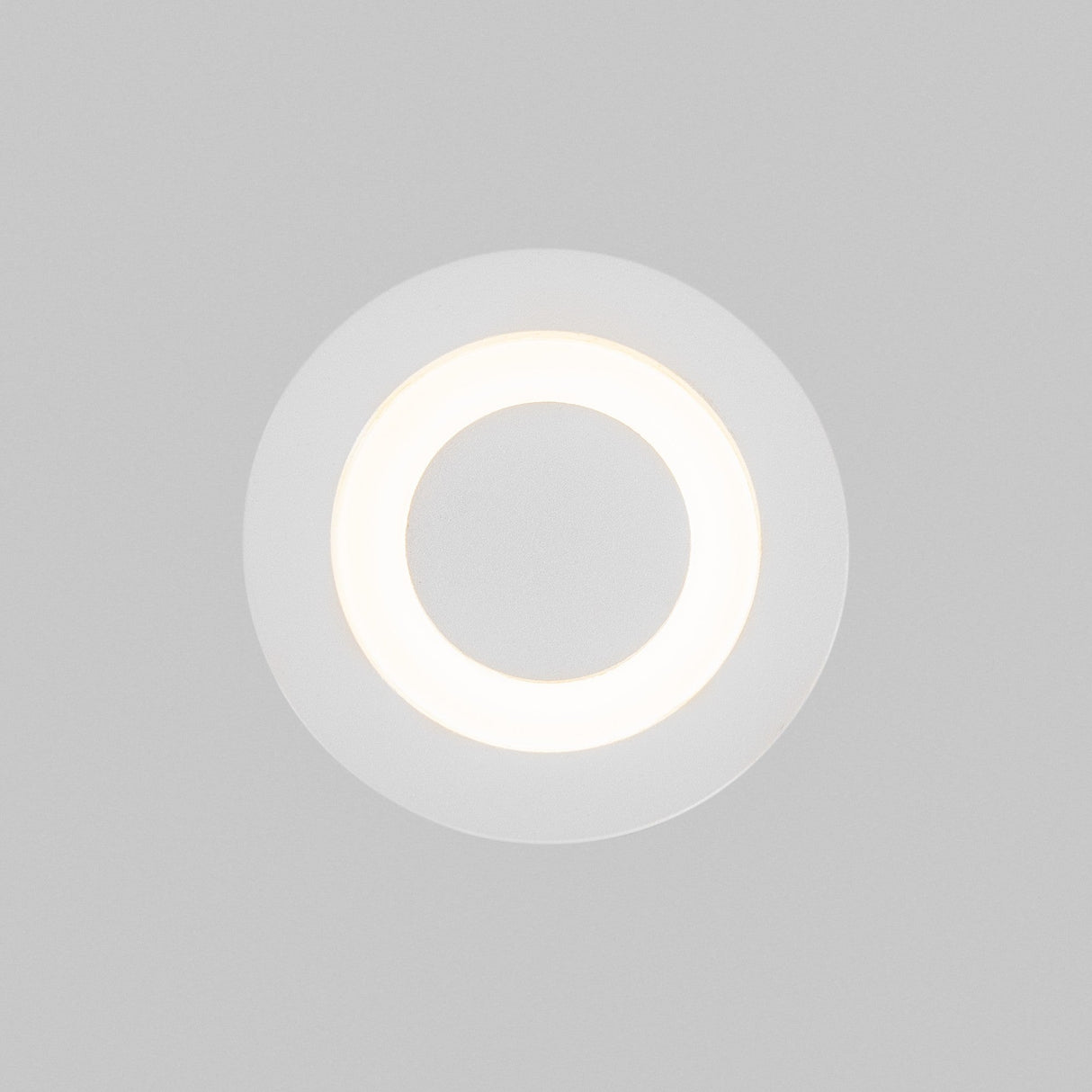 The Limo Outdoor LED Recessed Wall Light - White features a sleek circular design with a glowing white ring against a gray background.