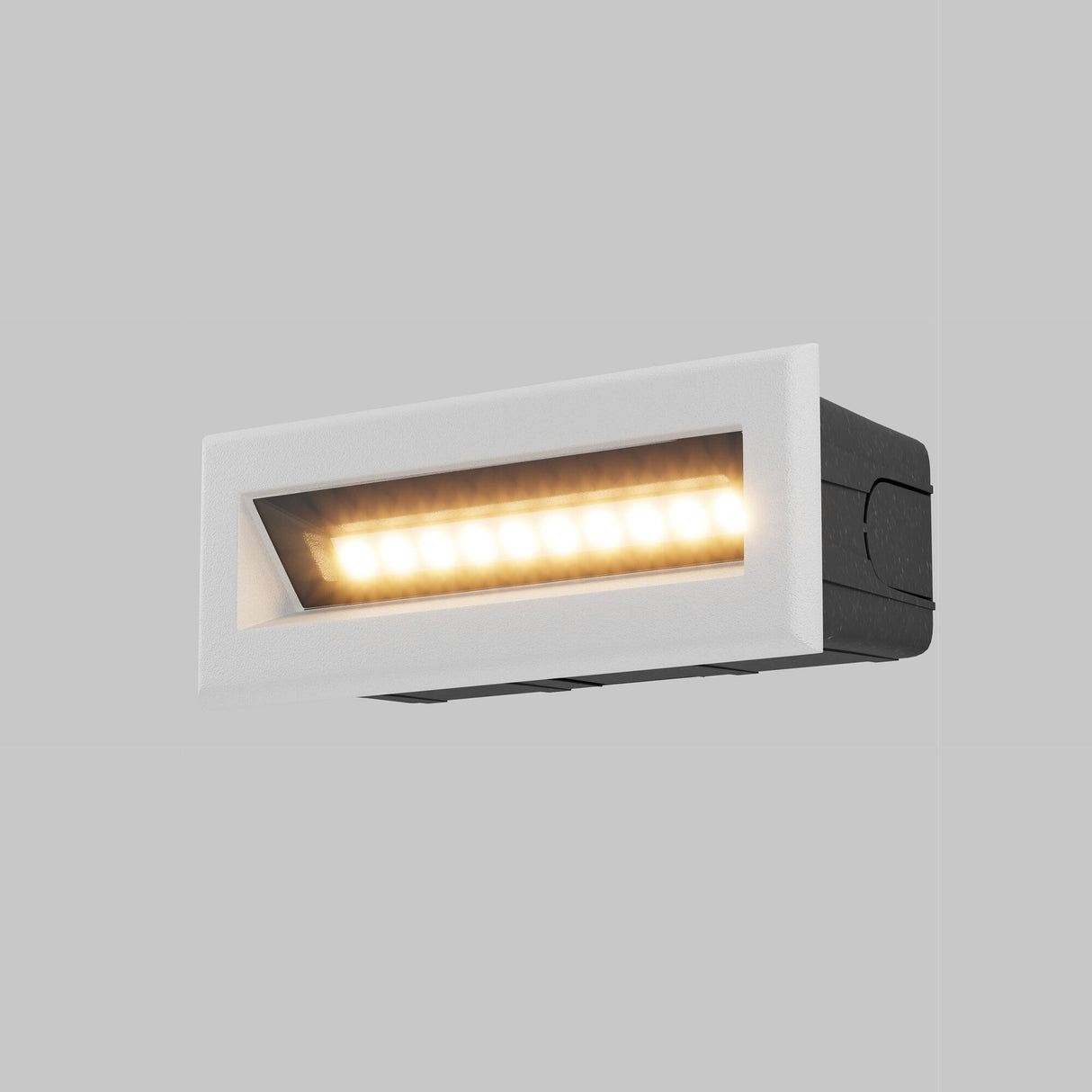 The Bosca Outdoor LED Long Recessed Wall Light - White is turned on, casting a warm glow. Against a plain gray background, its IP65-rated design with a sleek white frame and black casing stands out, showcasing modern style.