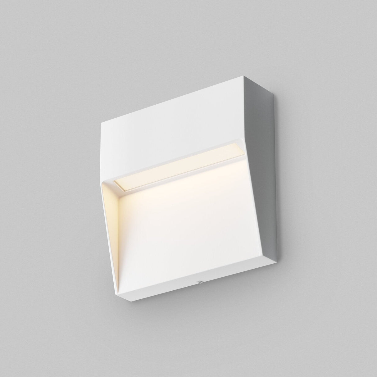 The Mane Outdoor LED Square Wall Light – White, featuring a minimalistic, rectangular design, emits a soft glow against a plain gray background.