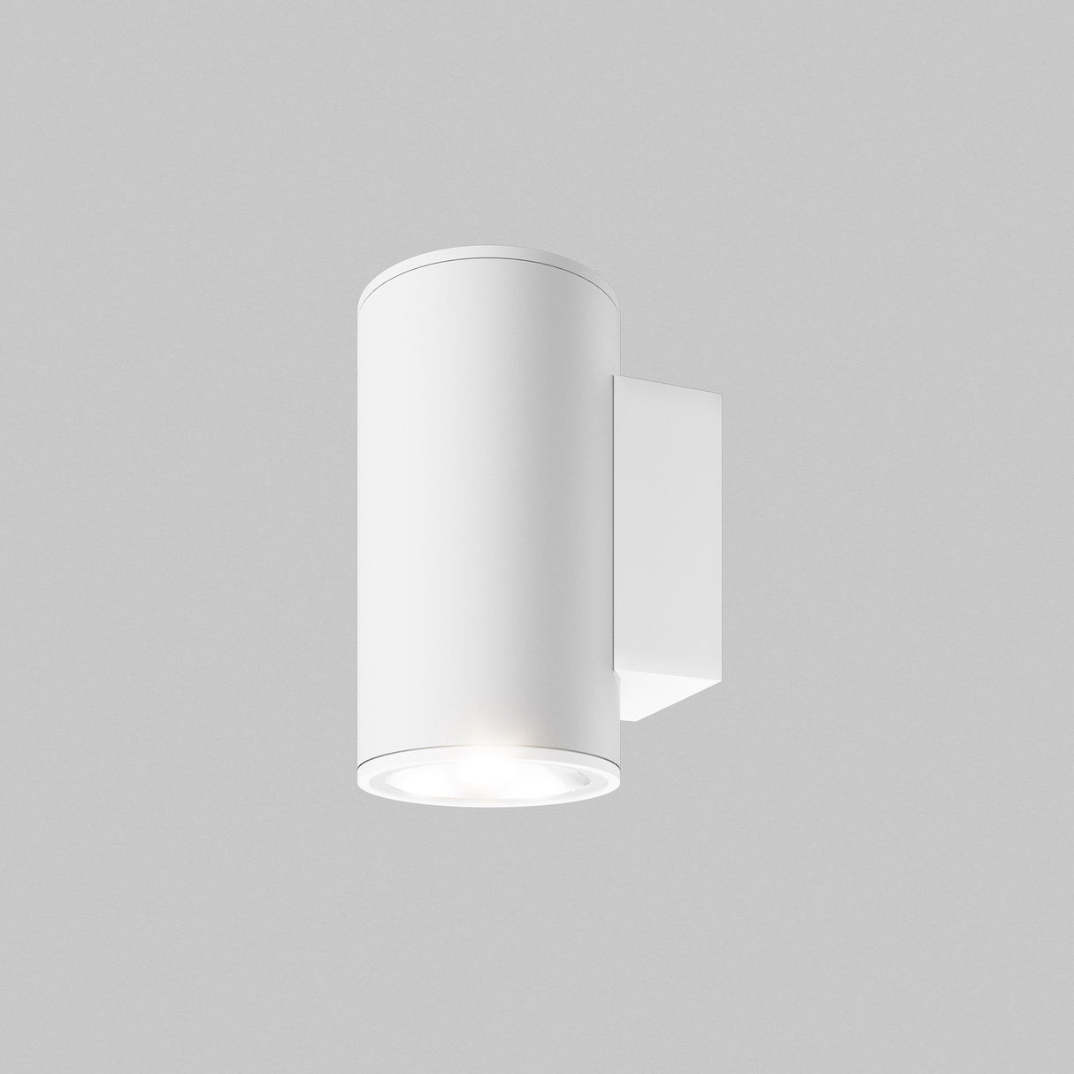 The Shim Outdoor Wall Light 10W 3000K - White is a modern, cylindrical fixture with an IP65 rating mounted on a gray wall. It emits a soft, warm glow (3000K) downward. Its sleek, minimalistic design is perfect for contemporary settings, indoors or outdoors.