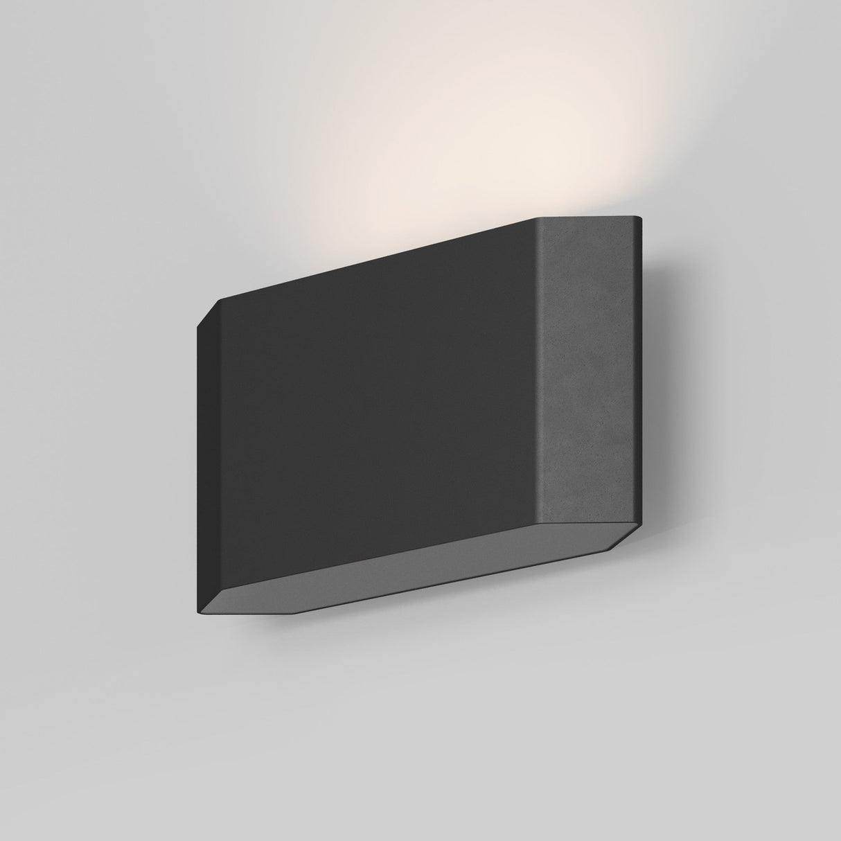 The Pull Outdoor LED Wall Light 5W 3000K in graphite emits a soft, warm glow upward against a plain white wall and boasts an IP54 rating for durability.