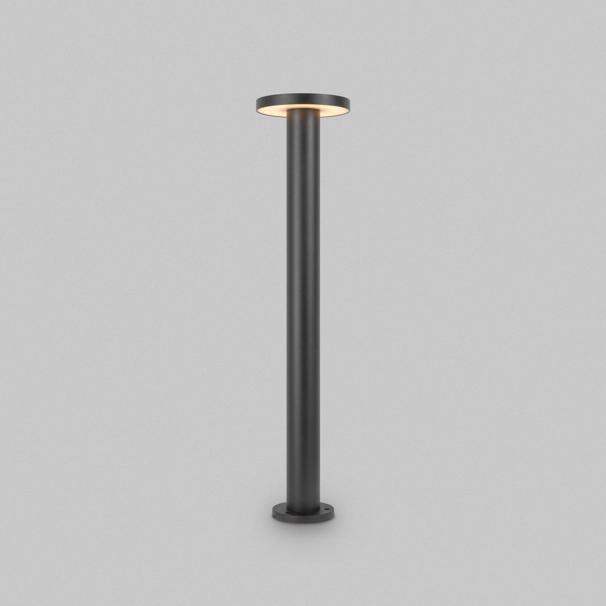 The Wald LED Bollard Light 3000K 12W in Graphite features an 80cm sleek, modern design with a black stand and a flat circular LED light on top, emitting a soft glow. It stands elegantly against a gray background, offering the sophisticated style of outdoor lighting indoors.