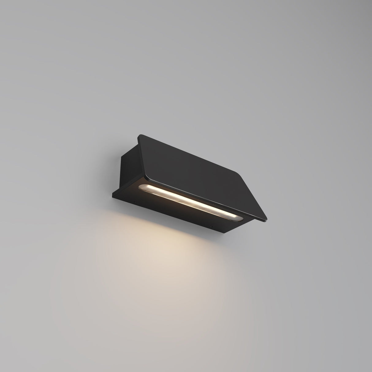 The Trupp Outdoor Wall Light 6W 3000K in Graphite features a modern, minimalist design with a sleek rectangular shape. Its IP54 rating ensures durability, while it casts warm, soft light downward to create a stylish ambiance on any blank wall.