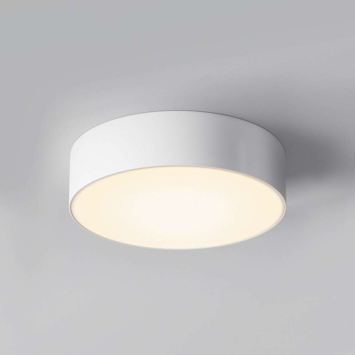 The Zon Outdoor Ceiling Light 30W 3000K - White emits a soft, warm glow with its modern, round design. Featuring a smooth cylindrical shape and an IP65 rating, this minimalist LED fixture is ideal for both indoor and outdoor use against light gray backgrounds.