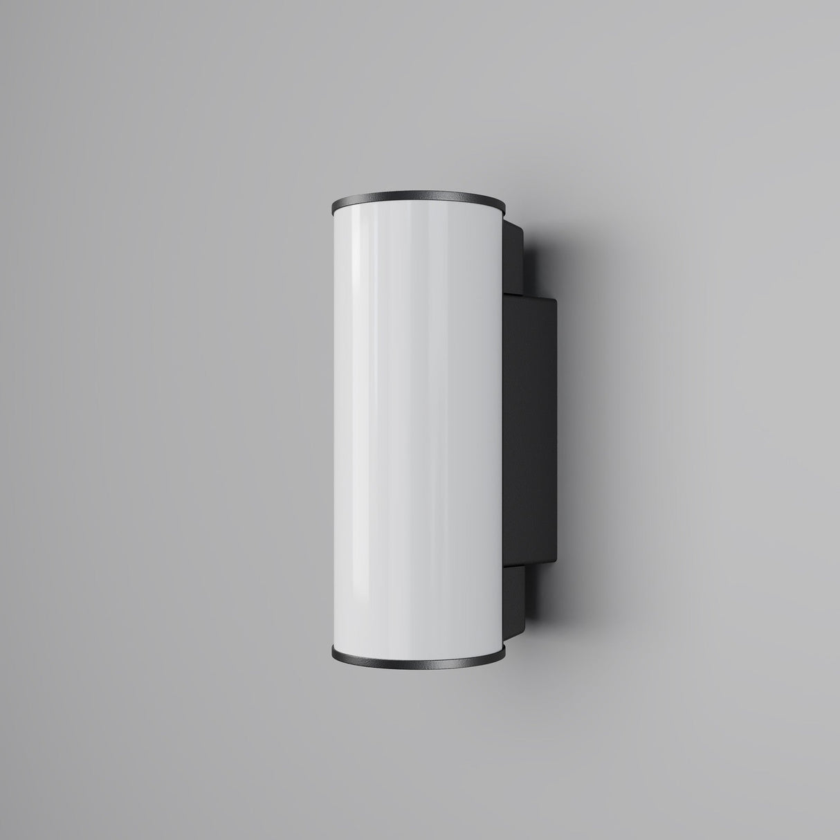 The Rock Outdoor LED Wall Light 3000K in Graphite is a sleek, modern LED wall light with energy efficiency and features a glossy white cylindrical body paired with black end caps, mounted on a light gray wall.