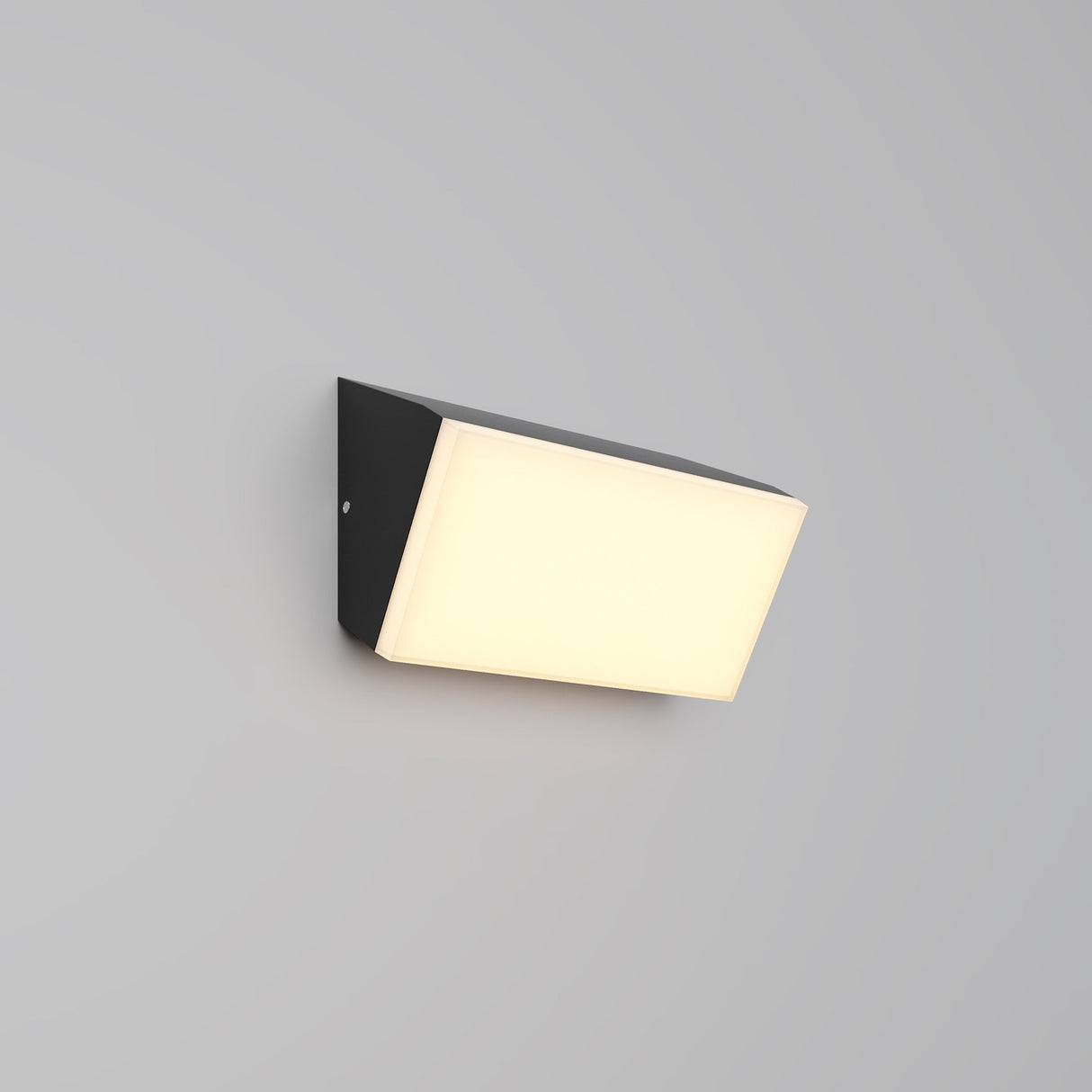 The Brick Outdoor LED Wall Light - Graphite (O436WL-L10GF3K) is a wall-mounted rectangular fixture with a bright white center. Its energy-efficient LED light slightly angles downward against a plain gray wall, softly illuminating the area.