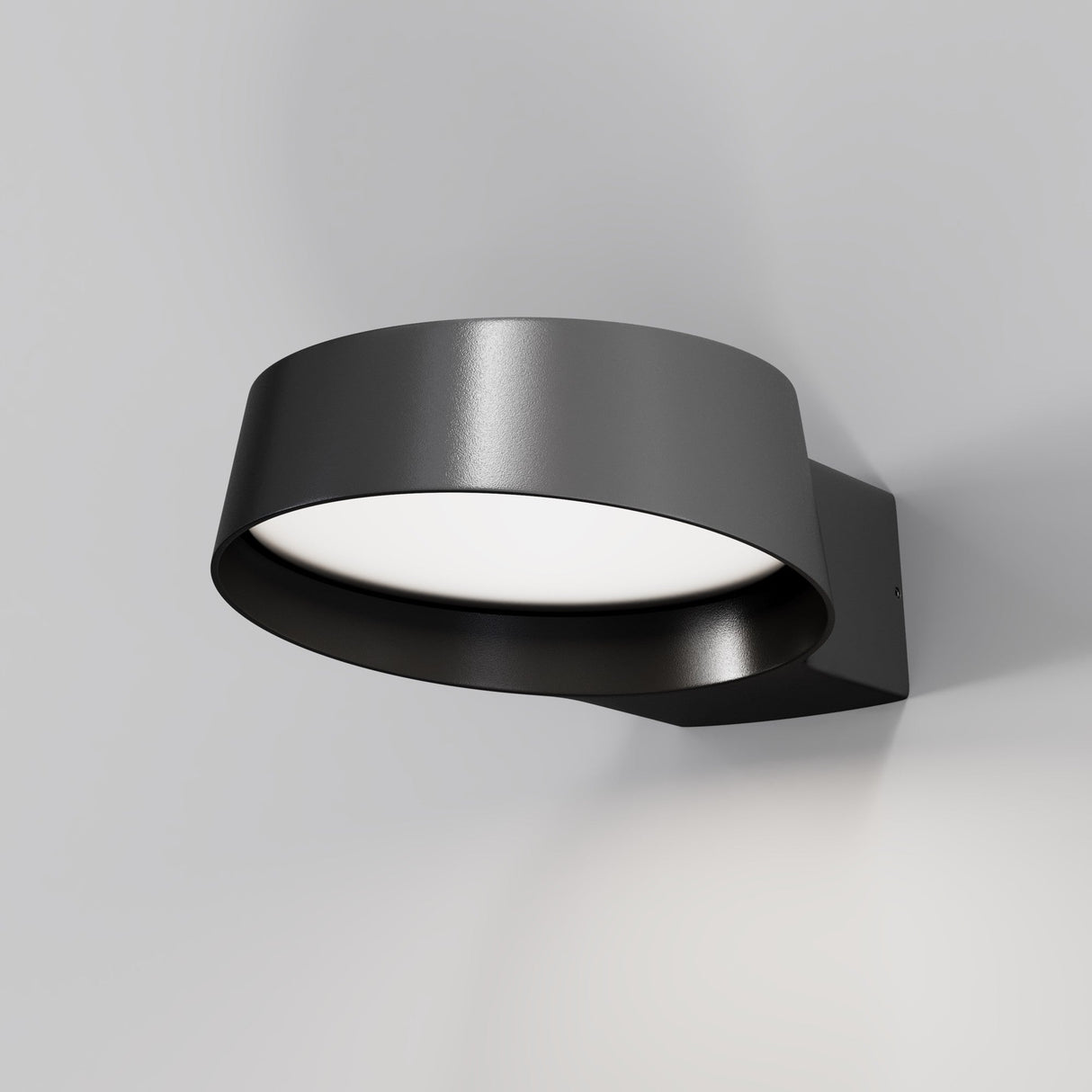 The Share Outdoor LED Wall Light 3000K in graphite is mounted on a white background, featuring modern, circular, minimalistic design with a wide rim and IP54 protection. It softly glows with a contemporary aesthetic.